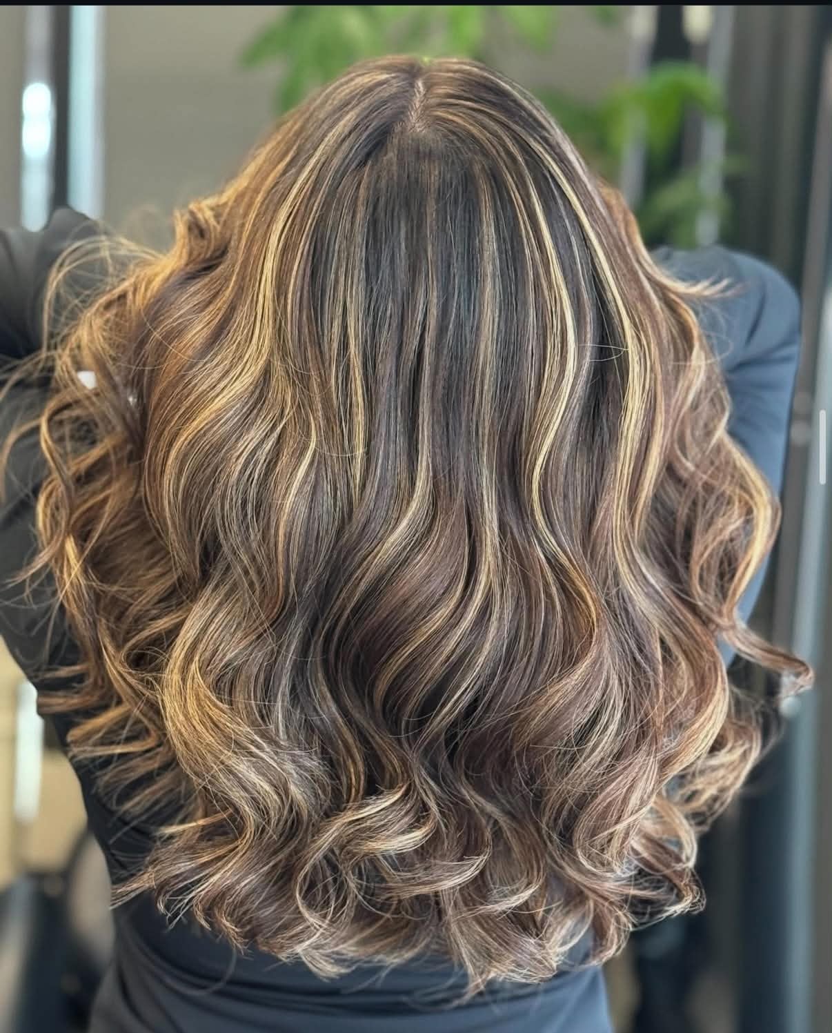 Long brunette curls with bright caramel ribbon highlights